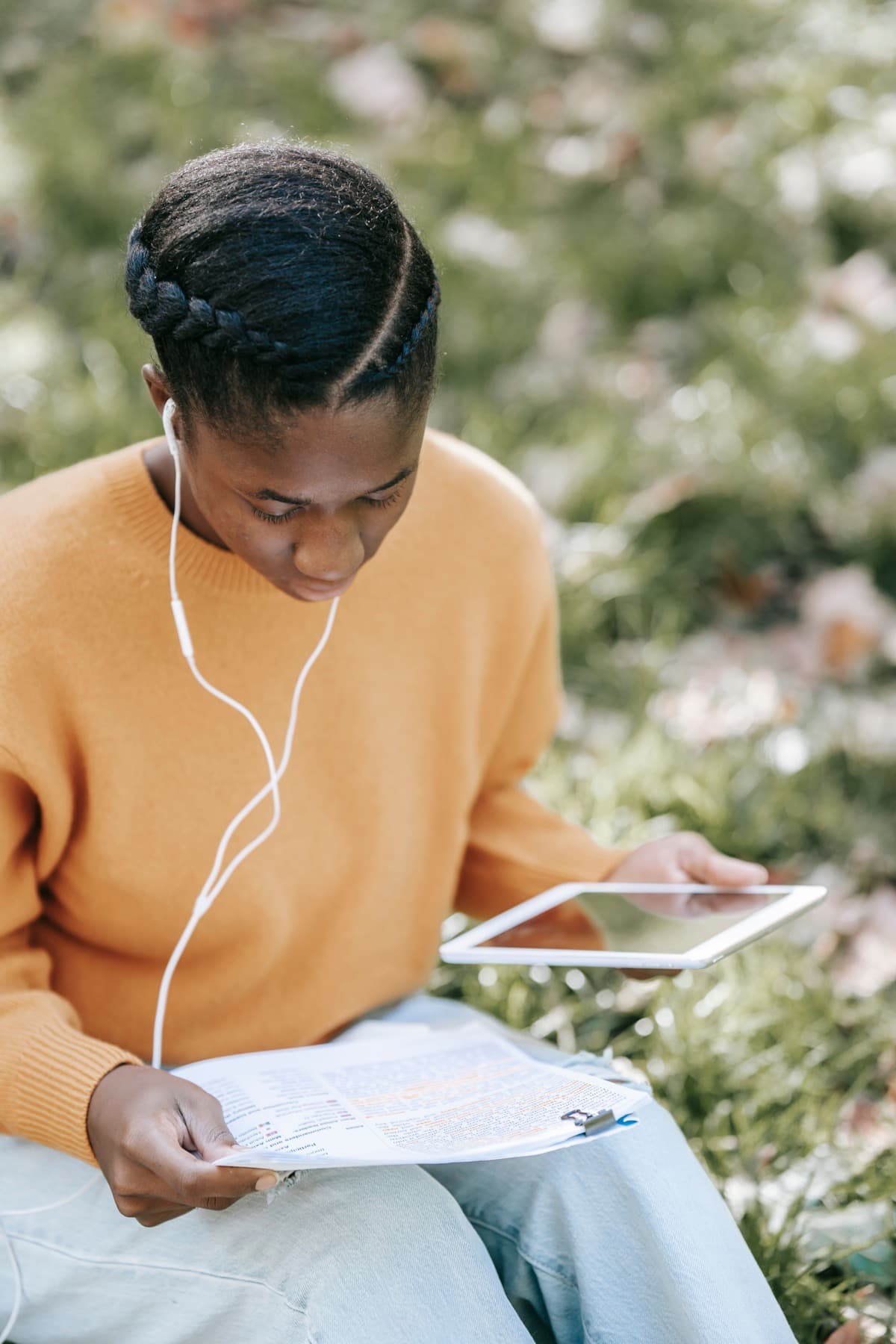 Young adult student studying outdoors with a tablet